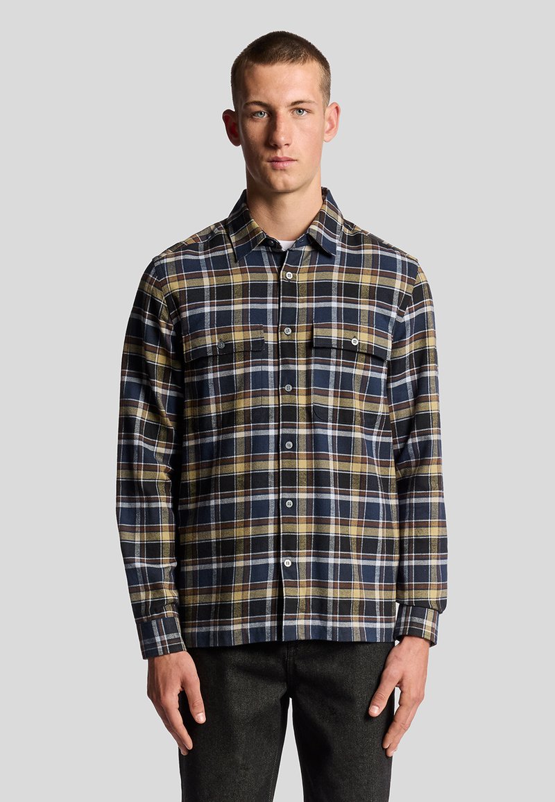 Camicia a quadri nei colori blu navy, giallo e bianco. Caratterizzata da colletto button-down, maniche lunghe e due tasche frontali con chiusura a bottone. Materiale in cotone.