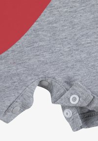 Γκρι βαμβακερό φορμάκι με μεγάλο κόκκινο σχέδιο καρδιάς. Διαθέτει κουμπιά πατιλέτας στο κάτω μέρος για εύκολο ντύσιμο. Μαλακή υφή και στρογγυλεμένες άκρες.