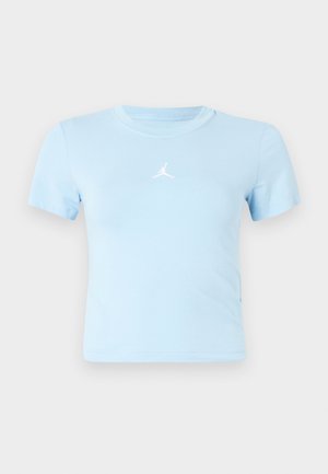 Šviesiai mėlyna trumpomis rankovėmis apkarpyta marškinėliai su mažu baltu „Jumpman“ logotipu, esant centruotam krūtinėje prieš paprastą foną.