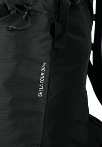 Zwarte Sella Tour 30 W rugzak met verstelbare banden en een trekkoordsluiting.