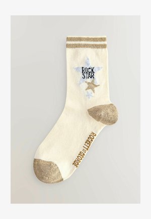 Kremne nogavice z zlatimi poudarki, ki imajo moder zvezdasti motiv in napis "ROCK STAR". Zlata konica in peta, rebrast rob. Teksturen material.