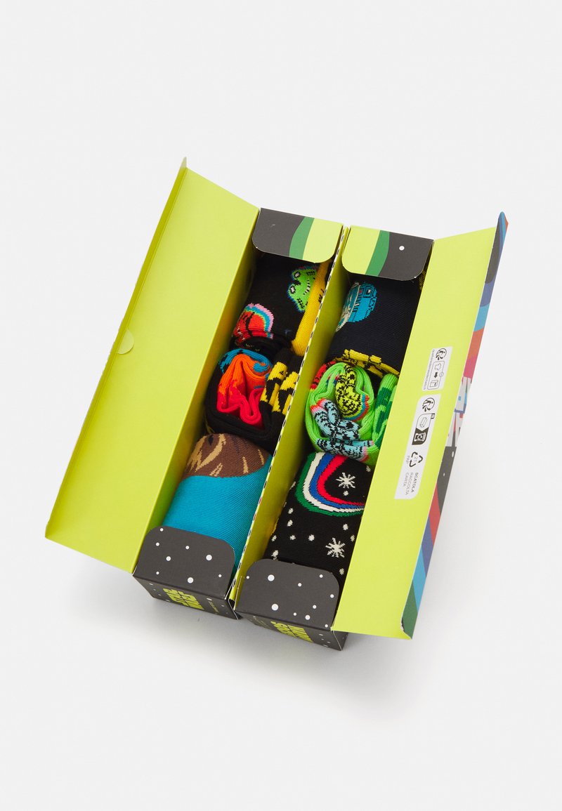 Ein Satz bunten Socken, die in einer grünen Box präsentiert werden. Die Socken zeigen verschiedene Muster, darunter kräftige Grafiken auf schwarzen, blauen und braunen Stoffen.