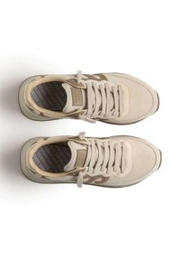 Sneaker casual beige con lacci, con collari imbottiti e soletti colorati, viste dall'alto su uno sfondo bianco.