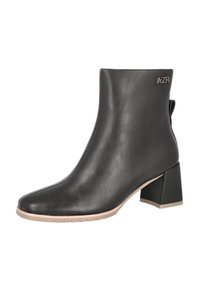 Botín de cuero negro con punta afilada, tacón cuadrado y suela beige. Detalle metálico del logo en el lateral. Textura suave y diseño elegante.