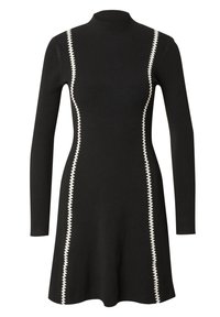 Schwarzes geripptes Kleid mit hohem Kragen und langen Ärmeln. Verfügt über kontrastierende weiße Zickzack-Nähte an den Seiten. A-Linien-Silhouette.