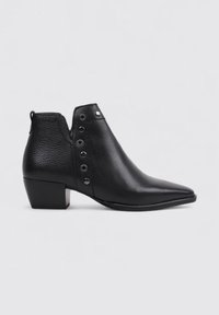 Botas de cuero negras hasta el tobillo con punta afilada, acabado texturizado y acentos de tachuelas plateadas. Diseño de tacón en bloque con una lengüeta en la parte trasera.