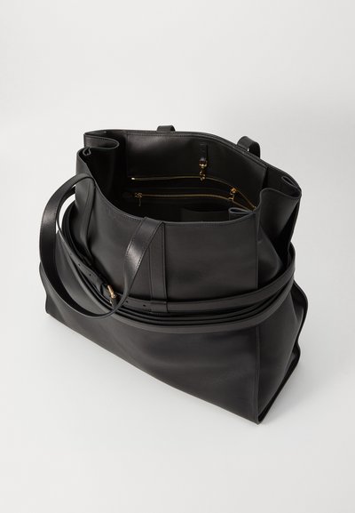 Black leather tote bag with a structured design, featuring dual handles and a zippered compartment with gold-tone hardware. Smooth texture.