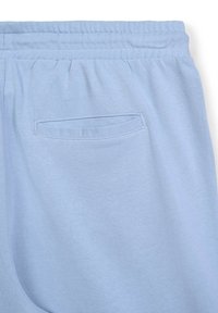 Pantaloni jogger blu chiaro in morbido cotone, dotati di cintura elasticizzata e una singola tasca posteriore con apertura arrotondata.