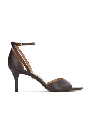 Sandală maro din piele cu toc înalt, cu vârf deschis și curea la gleznă. Are un toc subțire de tip stiletto și textură netedă. Accesorizată cu o cataramă aurie.