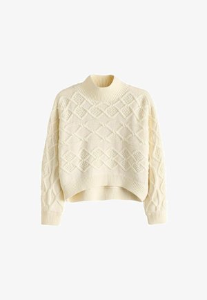 Rövidített, vastag, krém színű pulóver magas nyakkal, mely texturált gyémántmintákkal és bordázott mandzsettákkal, valamint aljjal rendelkezik.