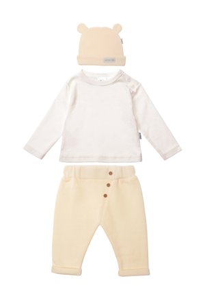 Cremfarbens Langarmshirt mit Schulterdruckknöpfen, kombiniert mit beigen Fleecehosen mit Knopfdetail und einer passenden Mütze mit Bärenohren.