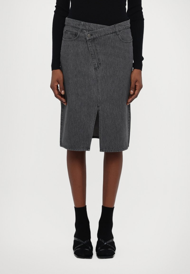 Grå denimminiskjørt med innsvingt midje, skrå frontseam og slisse foran. Har tradisjonell fem-lommersdesign og lukking med knapp foran.