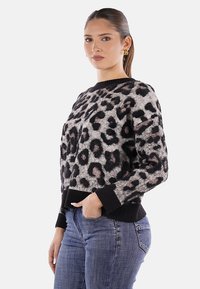 Maglione con stampa leopardata in morbido tessuto, con polsini e orlo a coste neri, presenta un collo rotondo e una vestibilità rilassata.