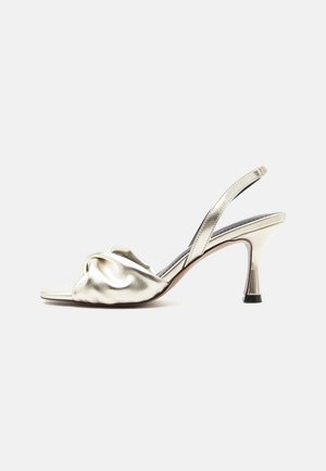Sandalo slingback argentato metallico con punta aperta, fascia anteriore arricciata e tacco sottile di media altezza su sfondo bianco.