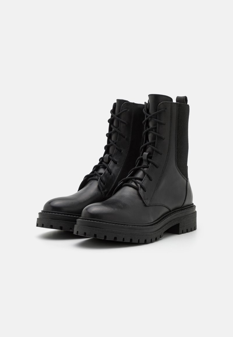 Czarne skórzane botki za kostkę z okrągłym noskiem, sznurowanym przodem, elastycznymi bocznymi panelami i masywnymi gumowymi podeszwami. Teksturowane wykończenie i wzmocnione szwy.