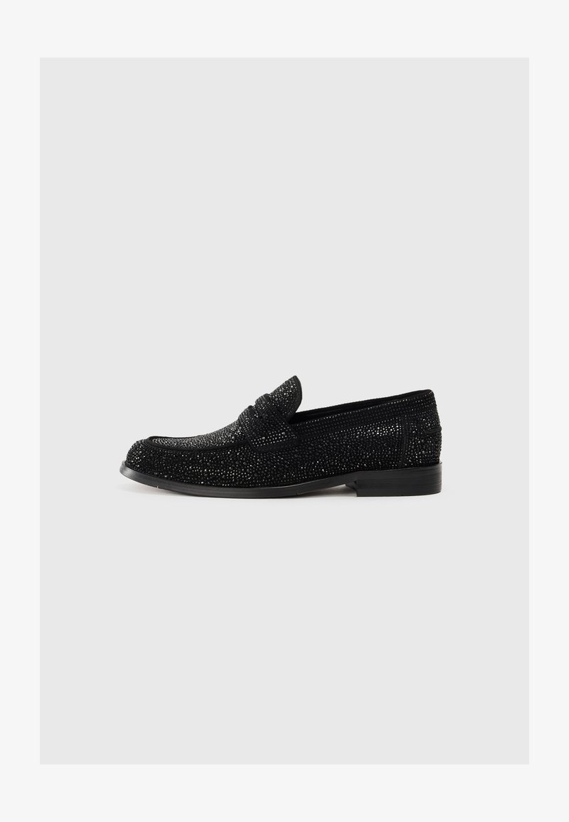 Mocassins noirs pour hommes avec des embellissements scintillants, un talon bas et un détail de lanière à centime, présentés en profil sur un fond uni.