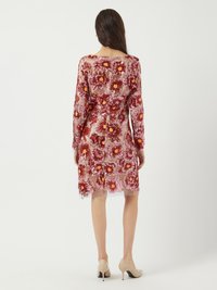 Robe florale transparente avec un motif de fleurs rouges et jaunes sur un fond clair ; manches longues, longueur genou et fermeture éclair dans le dos.