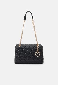 Sac à main noir matelassé avec bandoulière en chaîne dorée, dispose d'un charme en forme de cœur. Forme structurée, texture élégante et motif en diamant proéminent.