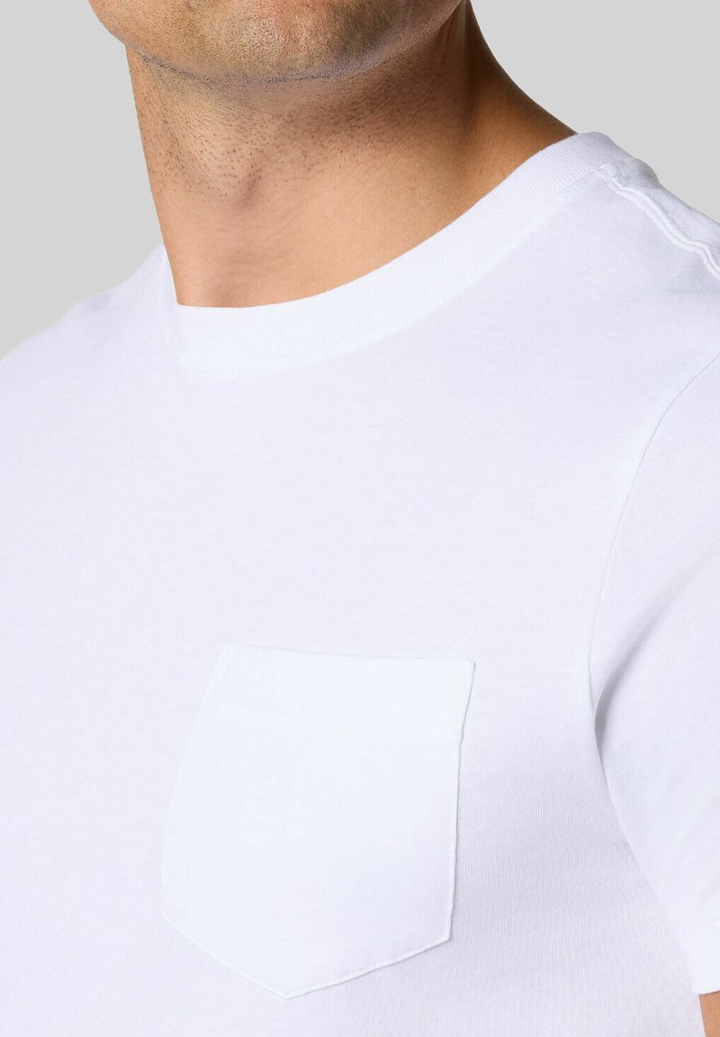 T-shirt in cotone bianco con scollatura tonda e taschino sul petto. Texture morbida e vestibilità classica senza decorazioni.