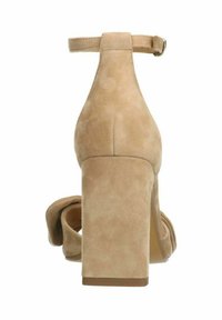 Beige suède hoge hakken sandaal met een ronde neusband, een brede blokhak en een enkelriempje. Versierde geknoopte detail aan de voorkant.