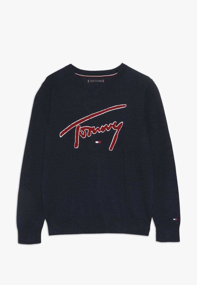 Pull col rond bleu marine avec inscription rouge "Tommy" et petit logo Tommy Hilfiger rouge, blanc et bleu sur la poitrine et le poignet de manche.