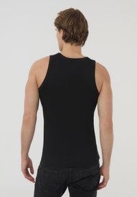 Top di raso nero a costine con scollatura arrotondata e spalline larghe, caratterizzato da un design aderente e una texture morbida. Vista posteriore mostrata.