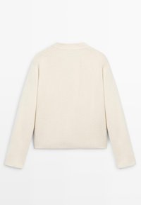Maglione lavorato a maglia color crema con scollo a girocollo, maniche raglan, polsini e orlo a costine, caratterizzato da una finitura morbida e testurizzata.