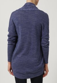 Long-sleeve sweater in dark blue knit, featuring a shawl collar and ribbed cuffs. The fabric has a subtle heathered texture and relaxed fit.