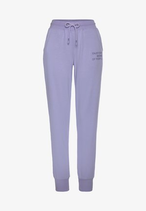 Paarse katoenen joggingsbroek met elastische tailleband en koord. Heeft geribbelde boorden en een tekstprint aan de rechterkant: "GENIET VAN ELK MOMENT VAN JE LEVEN."