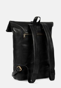 Black leather backpack with a textured surface, roll-top opening, gold-tone zipper pocket, and adjustable leather straps.