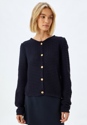 Navy knitted cardigan with a textured pattern, round neckline, and gold buttons. Long sleeves with ribbed cuffs. Casual fit.