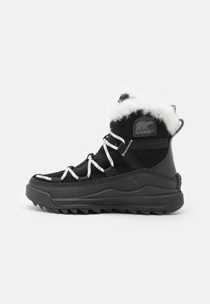 Botas de invierno negras con ribete de piel sintética, suela de goma y cordones blancos. Presenta un exterior impermeable y un patrón de suela resistente para mayor agarre.