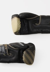 Guanti da boxe neri con dettagli in beige testurizzati; realizzati in pelle sintetica; presentano nocche imbottite e cuciture dettagliate.
