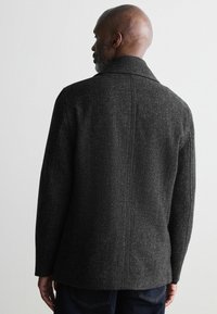 Chaqueta de mezcla de lana gris oscuro con un acabado texturizado, que cuenta con un cuello ancho y un corte recto. La vista trasera muestra un diseño limpio y minimalista.