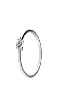 Silver ring with a smooth band featuring a decorative floral design and two small gemstones accenting the flower's center.
