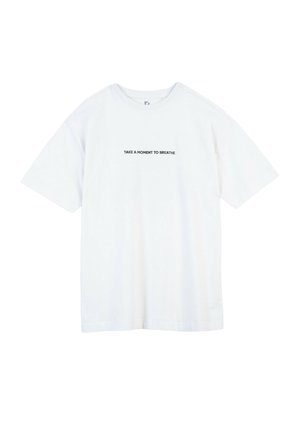 Biała koszulka z krótkim rękawem z czarnym napisem na środku klatki piersiowej: „ZATRZYMAJ SIĘ NA CHWILĘ I ODDYCHAJ.”