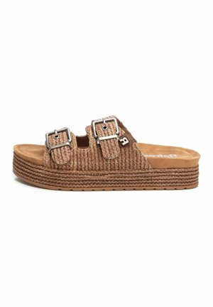 Sándala tejida marrón tipo slip-on con dos hebillas ajustables, parte superior texturizada y una suela intermedia de yute en capas, con una suela de goma plana.