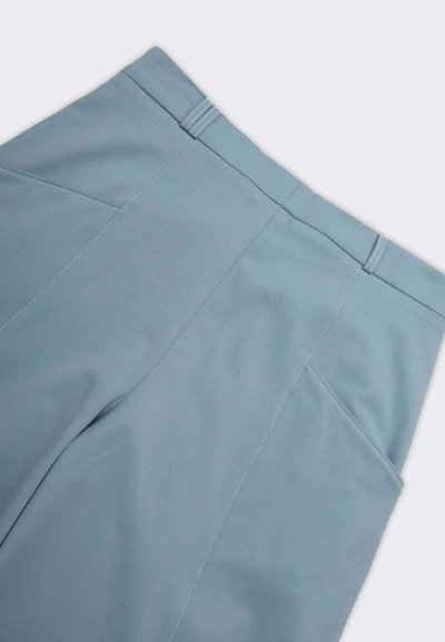 Pantaloni azzurri chiari con una texture liscia, dotati di una vita sagomata, cuciture pulite e tasche inclinate per un design strutturato.