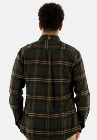 Groene geruite shirt van katoen, met lange mouwen en een knoopsluiting kraag. Het heeft gele en zwarte lijnen in een geruit patroon.