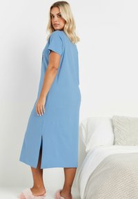 Ljusblå knälång nattklänning med korta ärmar, sidoreva och en avslappnad passform. Mjuk tyg med en slät textur.