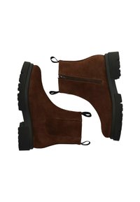Botas de tobillo de ante marrón con una suela de goma negra gruesa, cremallera lateral y dos pestañas para tirar. Textura suave con detalles de costura mínimos.