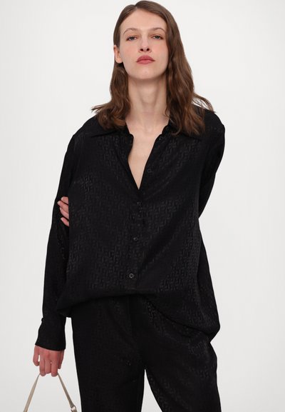 Zwarte button-up shirt met een subtiel patroon, lange mouwen en een losse pasvorm. Gemaakt van een gladde, gestructureerde stof.