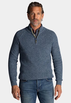 Gebreide blauwe pullovertrui met een hoge kraag en een halve rits, met ribbeltextuur en contrasterende details aan de binnenkant van de kraag.