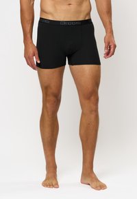 Črne bombažne bokserice s prilegajočim dizajnom, ki imajo elastičen pas z blagovno znamko Kappa in gladko teksturo.