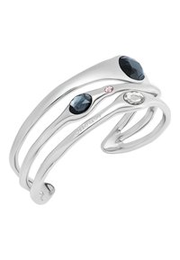 Pulsera de muñeca de plata con un diseño fluido, que presenta tres piedras preciosas facetadas: una azul oscuro, una rosa claro y una transparente, que añaden toques de color.