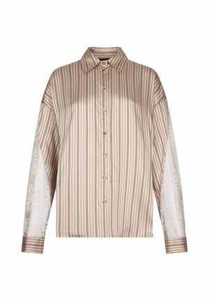 Chemise beige à manches longues boutonnée avec des rayures verticales noires et blanches et des panneaux en dentelle florale transparente sur les manches.