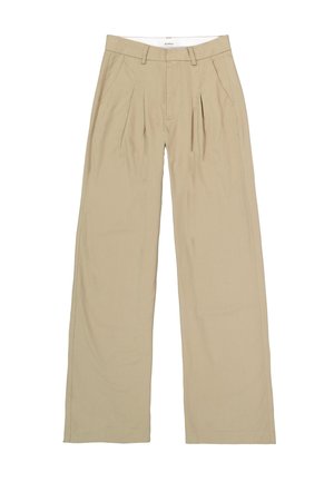 Pantalons beige à jambes larges en tissu doux, avec des plis sur le devant, une taille plate et des poches latérales ; des ourlets droits terminent le bas.