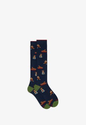Knee-high socks in dark blue with colorful dog patterns. Features green and red accents, made from a soft, textured fabric.