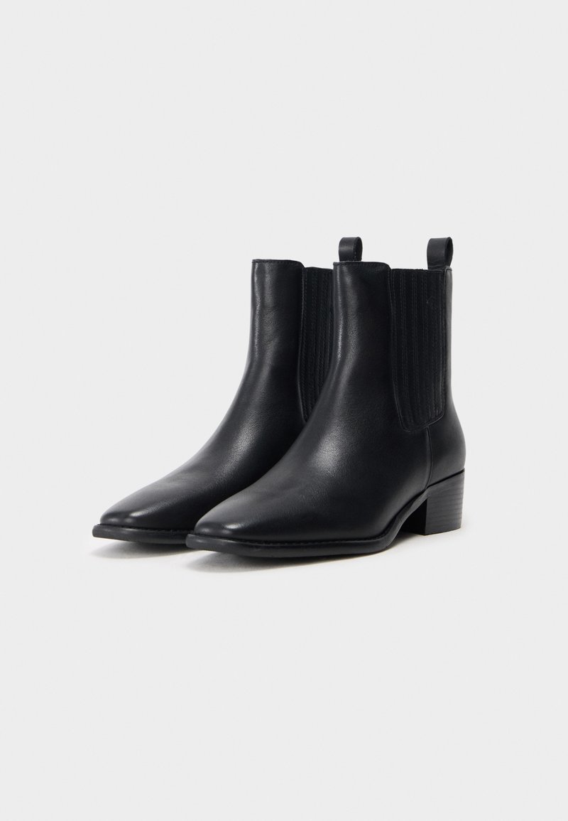 Schwarze Leder-Stiefeletten mit spitzen Zehen, elastischen seitlichen Einsätzen, kleinen Zuglaschen und niedrigen Blockabsätzen. Glatte Textur und schlichtes Design.