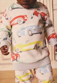 Fleece-Loungewear-Set mit bunten Auto-Prints in Rot, Blau, Grün und Gelb, mit gerippten grauen Bündchen und Bund.